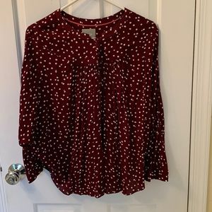 Loose and “drapey” burgundy pleated top with 8 buttons in the front.